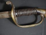 an old sword with a gold handle on a black surface