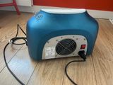 an image of a blue and white electric heater on a wooden floor