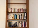 a book shelf with books on it in the corner of a room