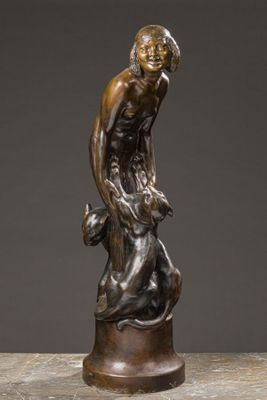 a bronze statue of a man holding a dog on a pedestal