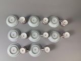 six cups and saucers are arranged on a gray surface