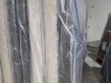 de nombreux rouleaux de matelas emballés dans du plastique dans un entrepôt