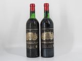deux bouteilles de vin posées l'une à côté de l'autre sur une surface blanche