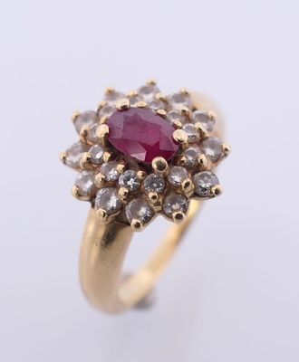 un gros plan d'une bague en or sertie d'un rubis entouré de diamants blancs