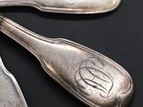 three spoons that are sitting on a black table