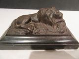 a statue of a lion laying on top of a base