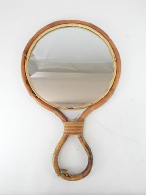 an image of a wooden hand mirror hanging on a wall