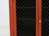 an orange cabinet with glass doors and a door handle