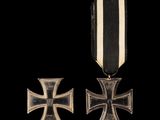 un gros plan d'une médaille et d'une croix sur fond noir