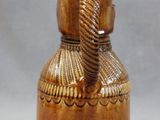 a brown vase with a knot on the handle