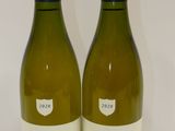 deux bouteilles de vin blanc posées l'une à côté de l'autre sur une table