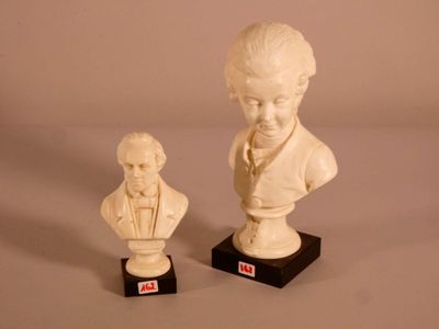deux statues représentant un garçon et un buste de garçon