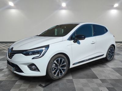 Une voiture blanche est garée sur un sol en carrelage à damier.