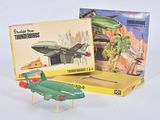 un petit avion et une boîte de jouets posés sur une surface blanche