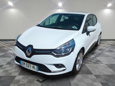 la voiture blanche est garée sur un sol en damier dans le garage