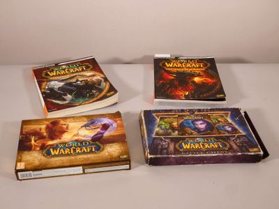 Quatre livres sur World of Warcraft sont alignés sur une table