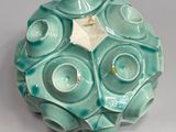 a small teal colored candle holder with a star on it