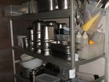 une étagère en métal sur laquelle sont posés des casseroles et des poêles