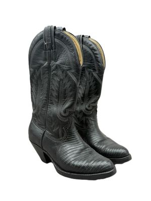 une paire de bottes de cow-boy noires sur fond blanc