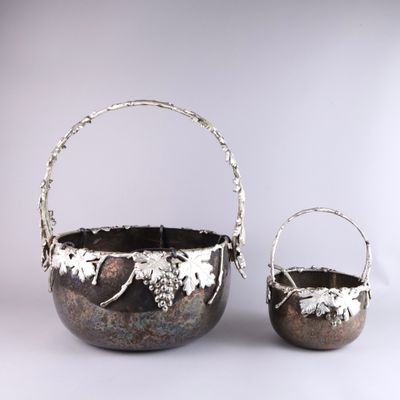 a pair of silver metal baskets with handles and handles