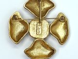 a gold brooch with four petals on it