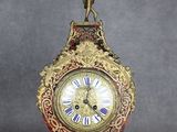 une horloge posée sur un socle, surmontée d'un oiseau