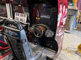 une photo d'une console de jeux installée dans un garage, avec un volant