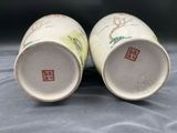 pair of chinese porcelain vases with trees on them on a table