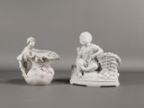 paire de figurines en porcelaine blanche représentant un garçon et une fille assis sur un panier