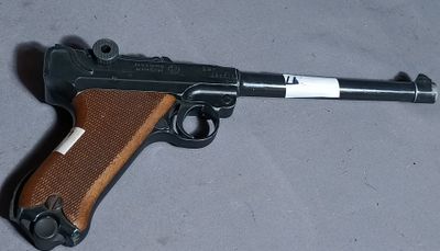 gun on the table is brown and black with a white stripe