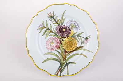 l'image d'une assiette avec des fleurs sur une surface blanche