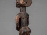 a wooden statue of a woman holding a baby in her arms