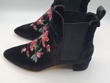 une paire de bottines noires en daim ornées de fleurs brodées sur le côté