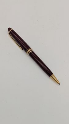 un gros plan d'un stylo posé sur une table blanche