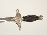 a silver and black sword with a red stone on it