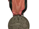 une ancienne médaille avec un ruban rouge sur fond blanc
