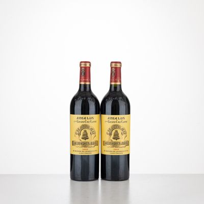 two bottles of wine sitting on top of a table next to each other
