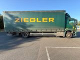 a green truck that is parked in a parking lot