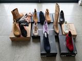 Plusieurs paires de chaussures sont alignées sur des cartons posés par terre