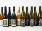 plusieurs bouteilles de vin sont alignées sur une surface blanche