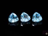 three trillion cut blue topazte gems on a black background
