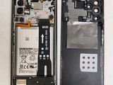 the back of a cell phone with a broken battery and a broken battery cover