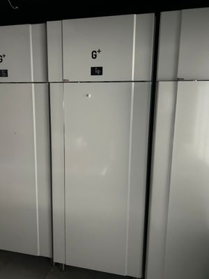 Plusieurs réfrigérateurs blancs sont alignés les uns à côté des autres dans une pièce