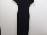 a black dress hanging on a white wall in a room