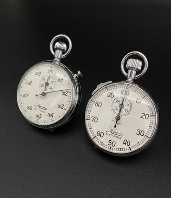 deux horloges posées sur une surface noire