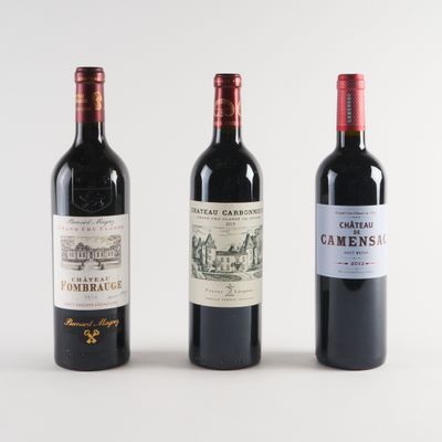 trois bouteilles de vin sont alignées sur une surface blanche
