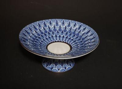 a blue and white bowl with a candle in it