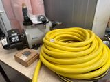 un tuyau jaune posé sur une table, à côté d'une pompe