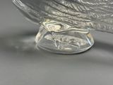 a glass bird that is sitting on top of a glass bowl