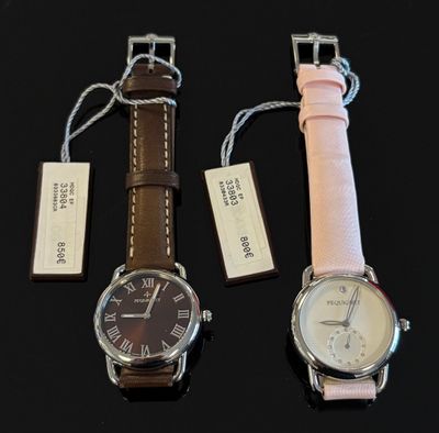 deux montres sont posées l'une à côté de l'autre sur une surface noire